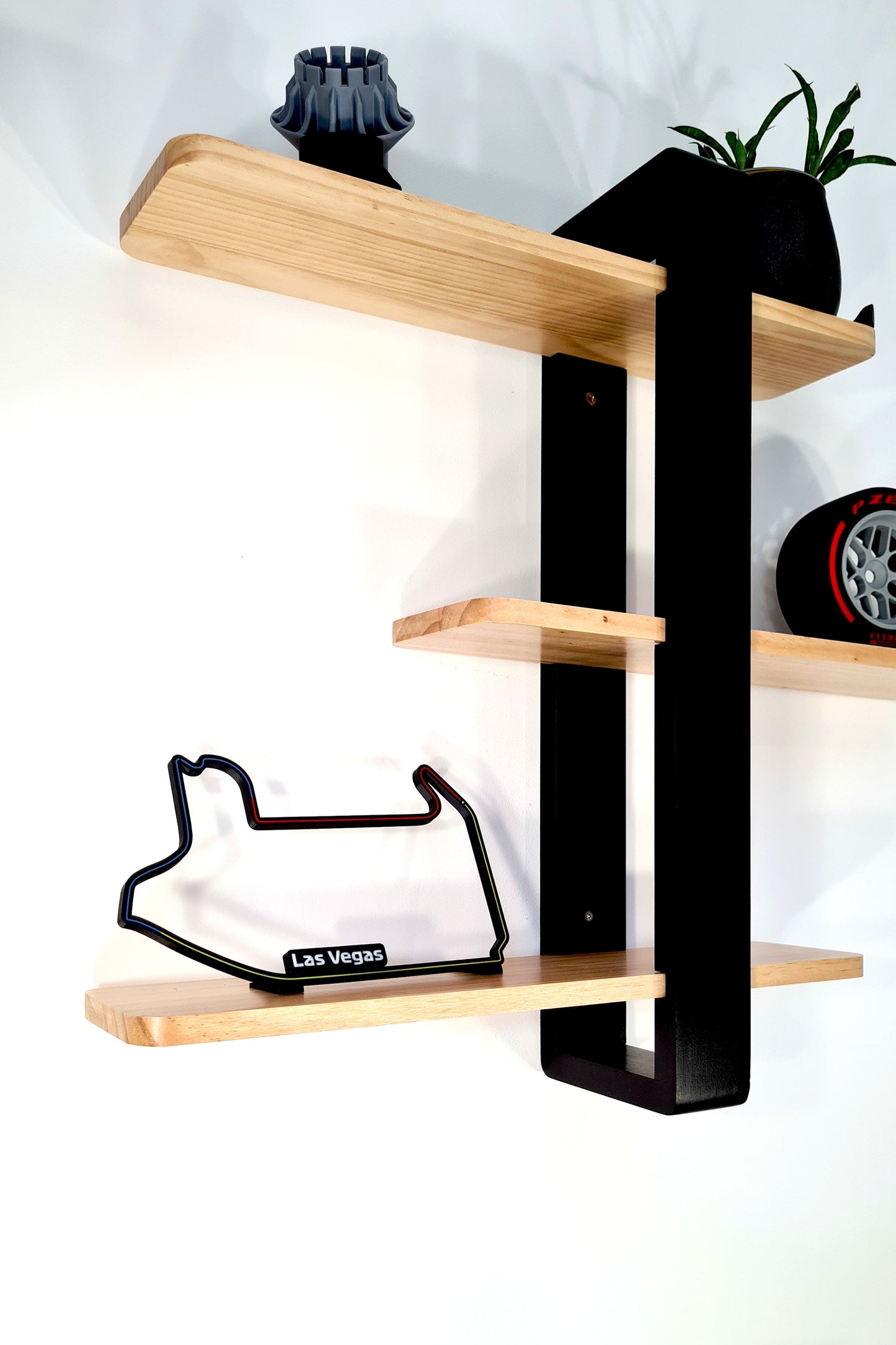 Las Vegas F1 3D track replica, Pirelli F1 tire, and wheel nut display for motorsport fans.