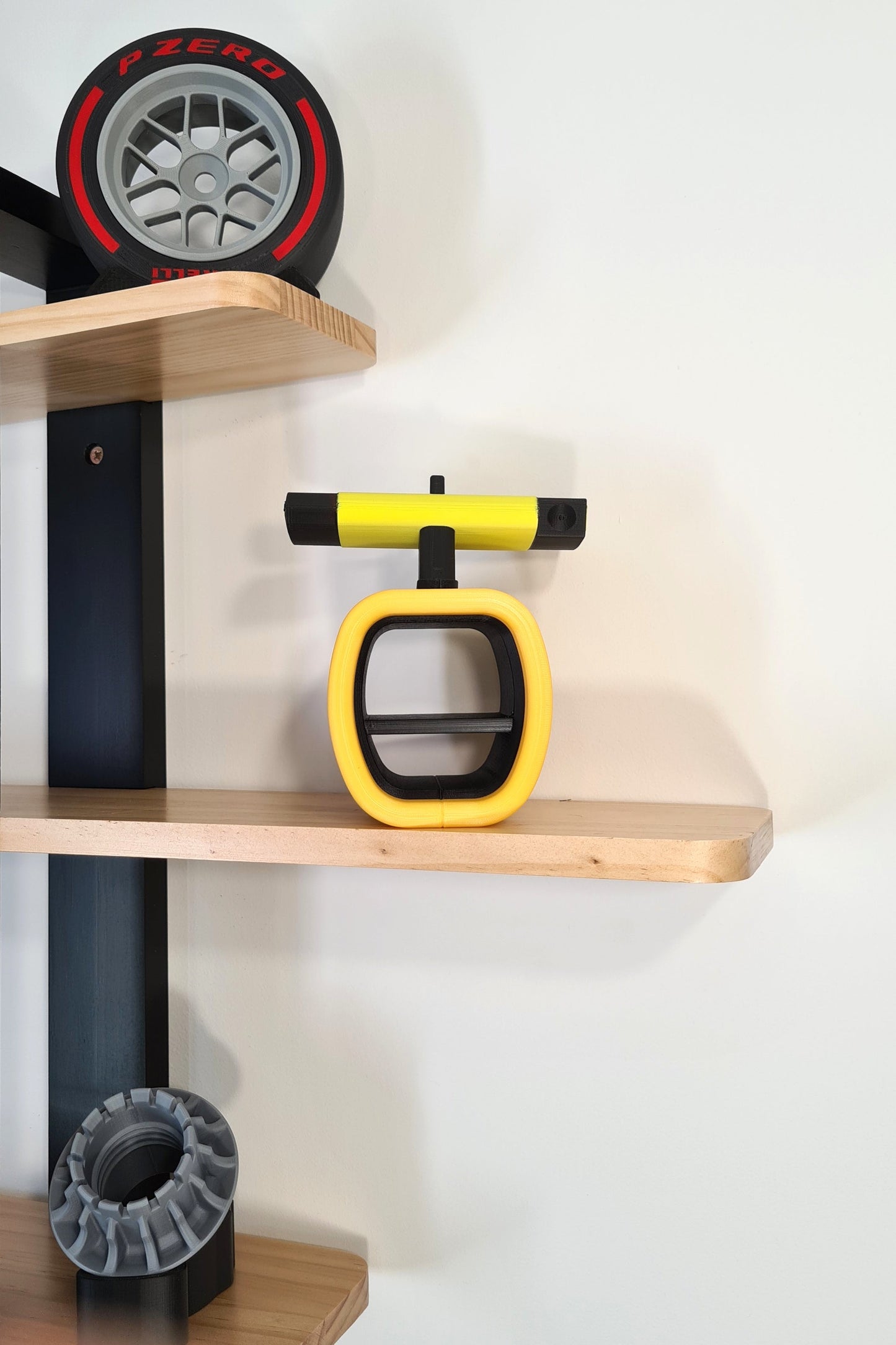 Yellow and black F1 steering wheel replica display, with Pirelli P Zero red tire model, perfect F1 fan gift.