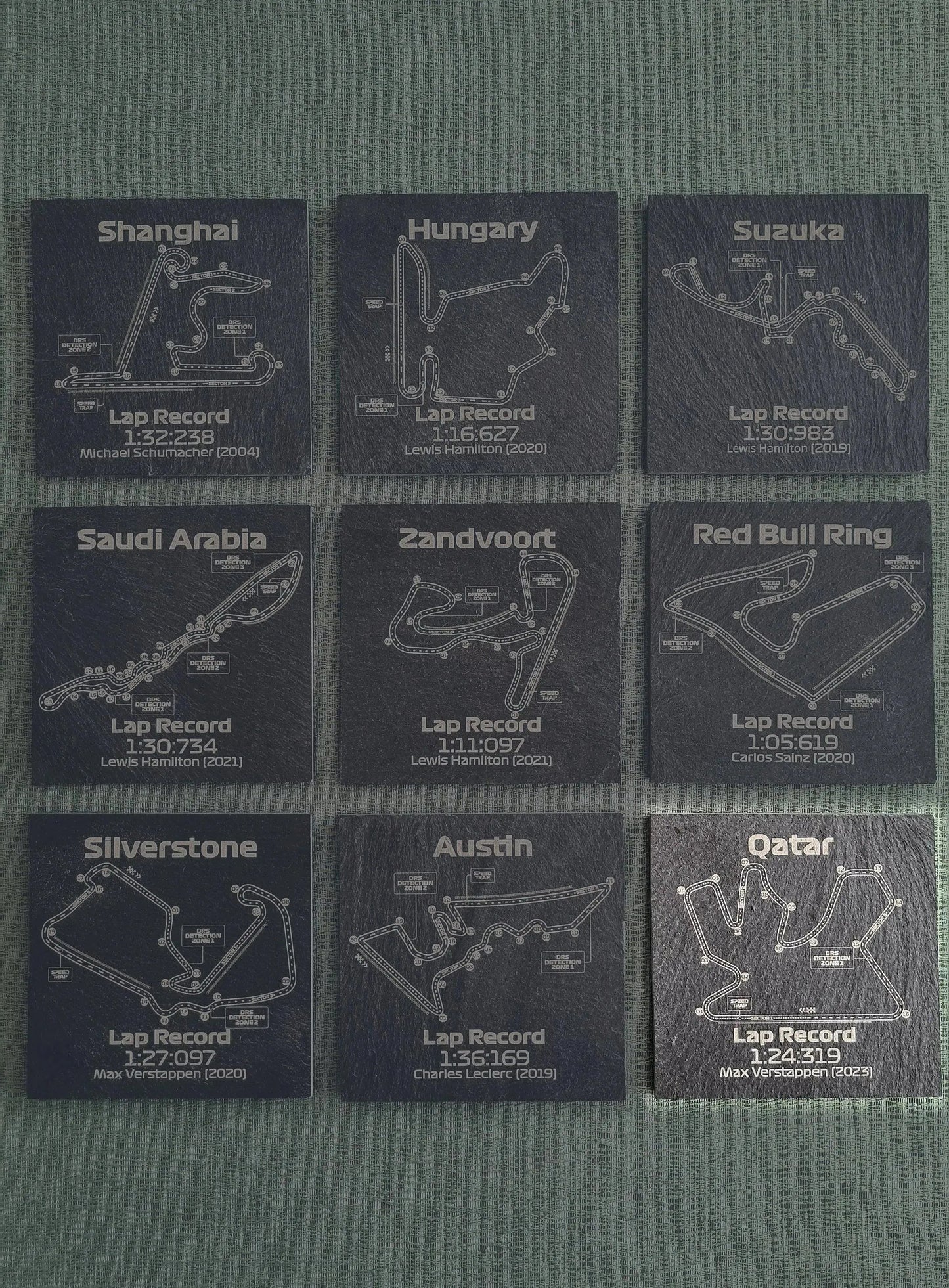 Set of 9 F1 circuit slate coasters featuring various track maps and lap records, perfect Formula 1 fan gift.