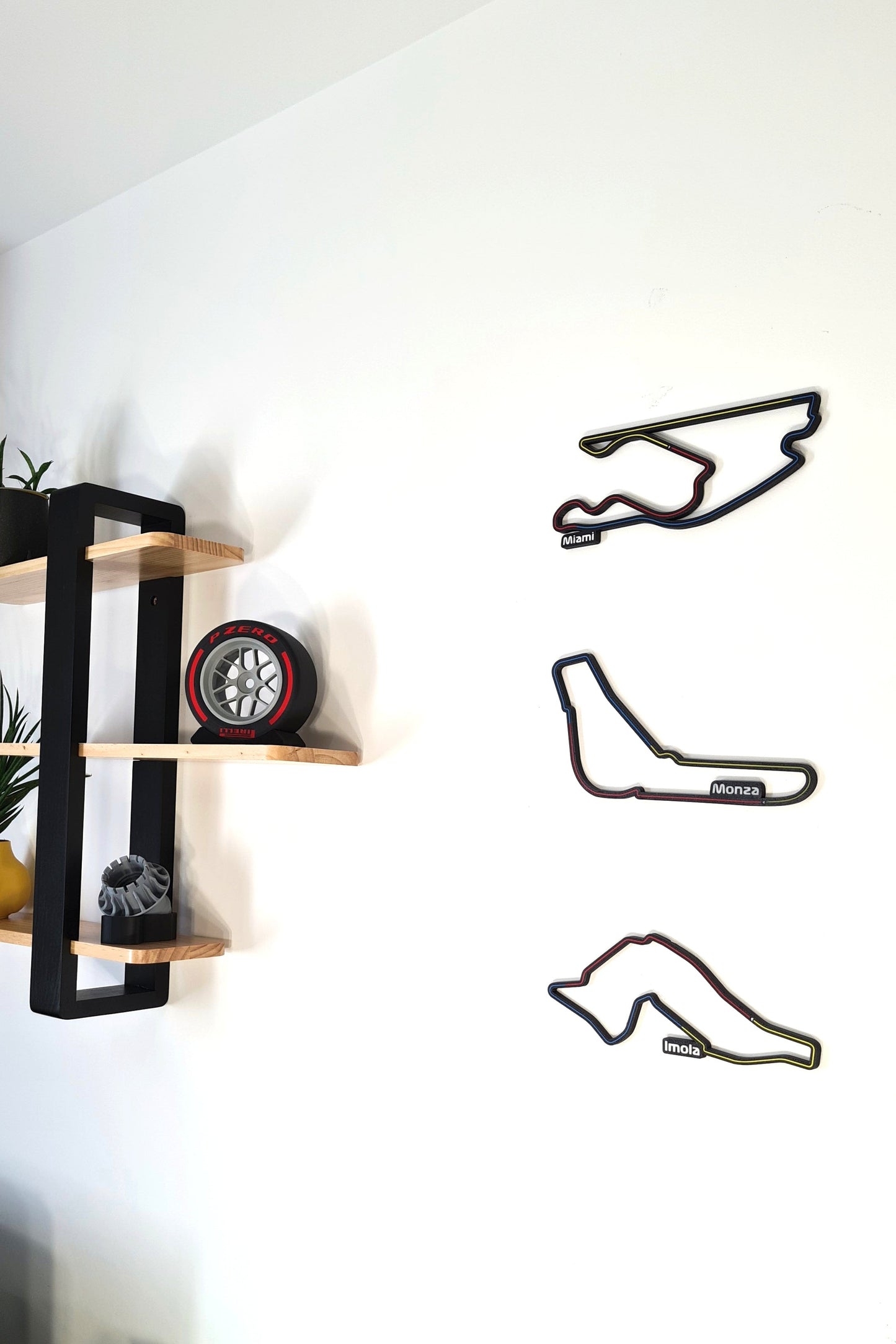 F1 motorsport decor featuring Miami, Monza, Imola 3D track wall art and Pirelli tire replica.