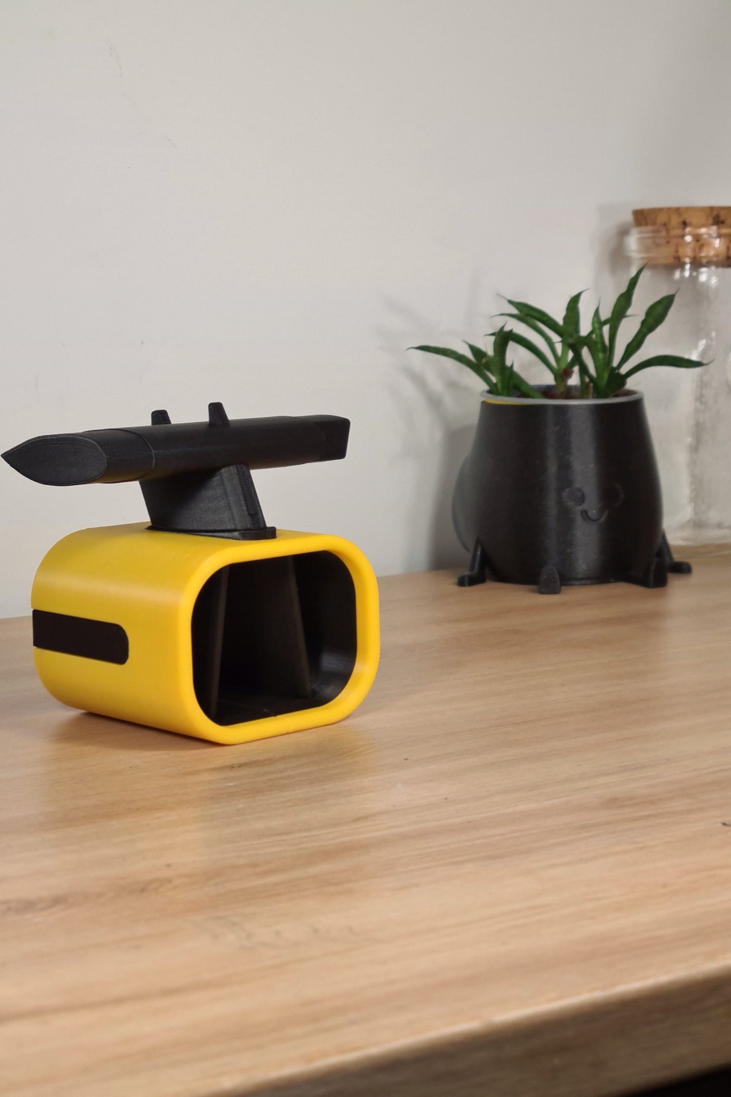 3D printed yellow F1 car airbox phone stand, ideal Formula 1 fan desk gift.