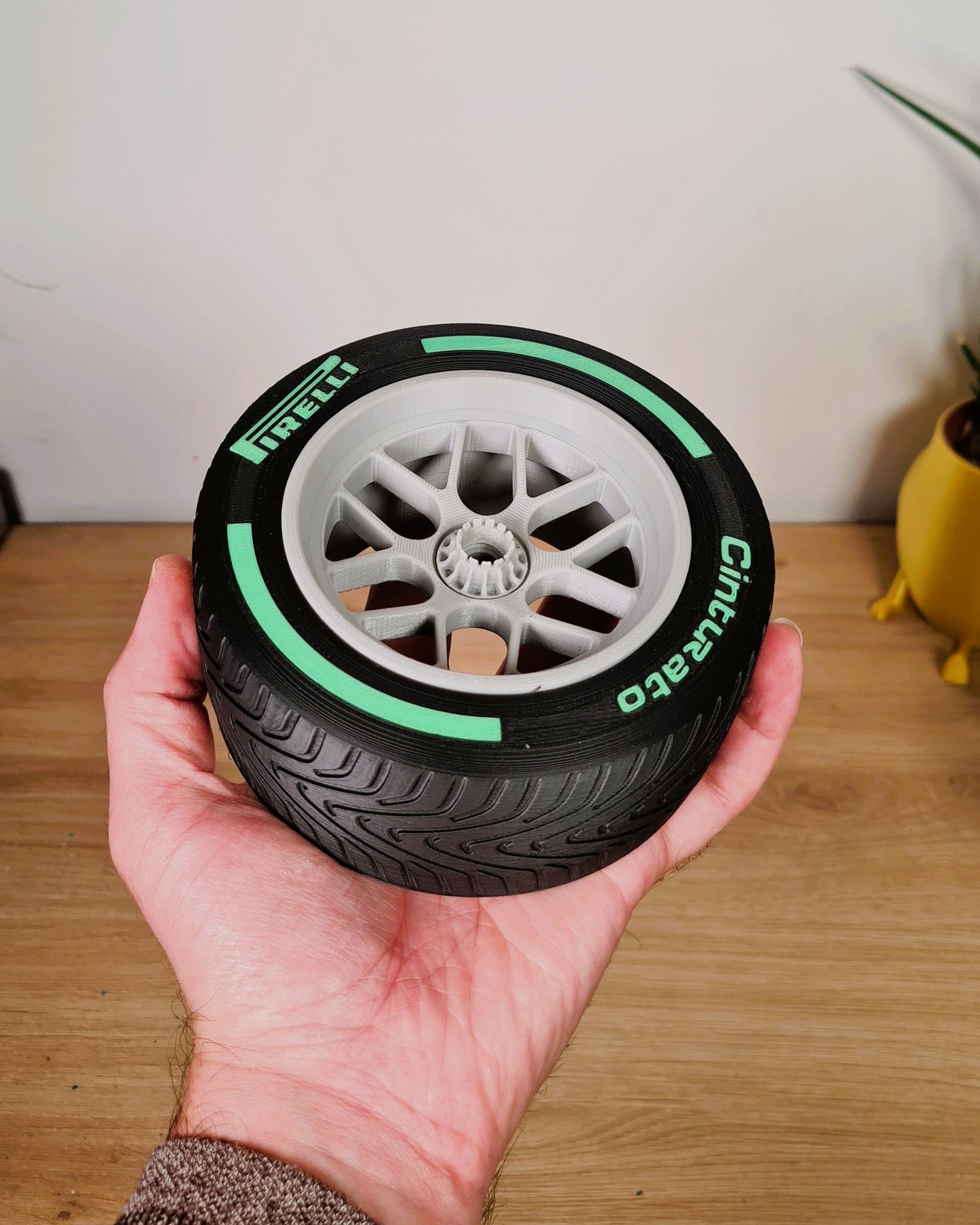3D printed Formula 1 Pirelli Cinturato intermediate tire replica with green stripe and grey wheel, perfect F1 fan desk decor.