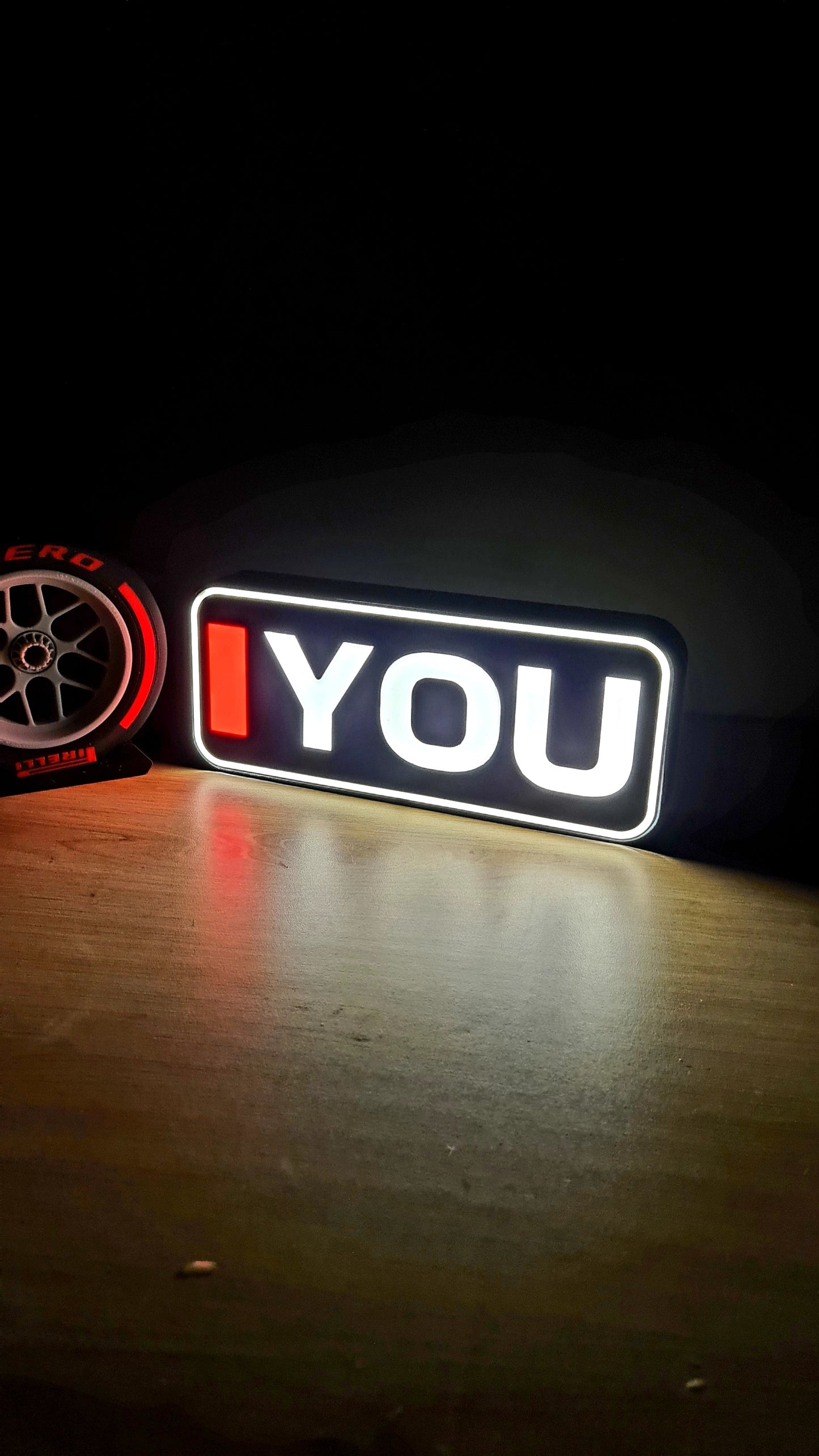 Romantic 'I love you' LED light sign with F1 Pirelli soft tire replica, perfect F1 fan gift.