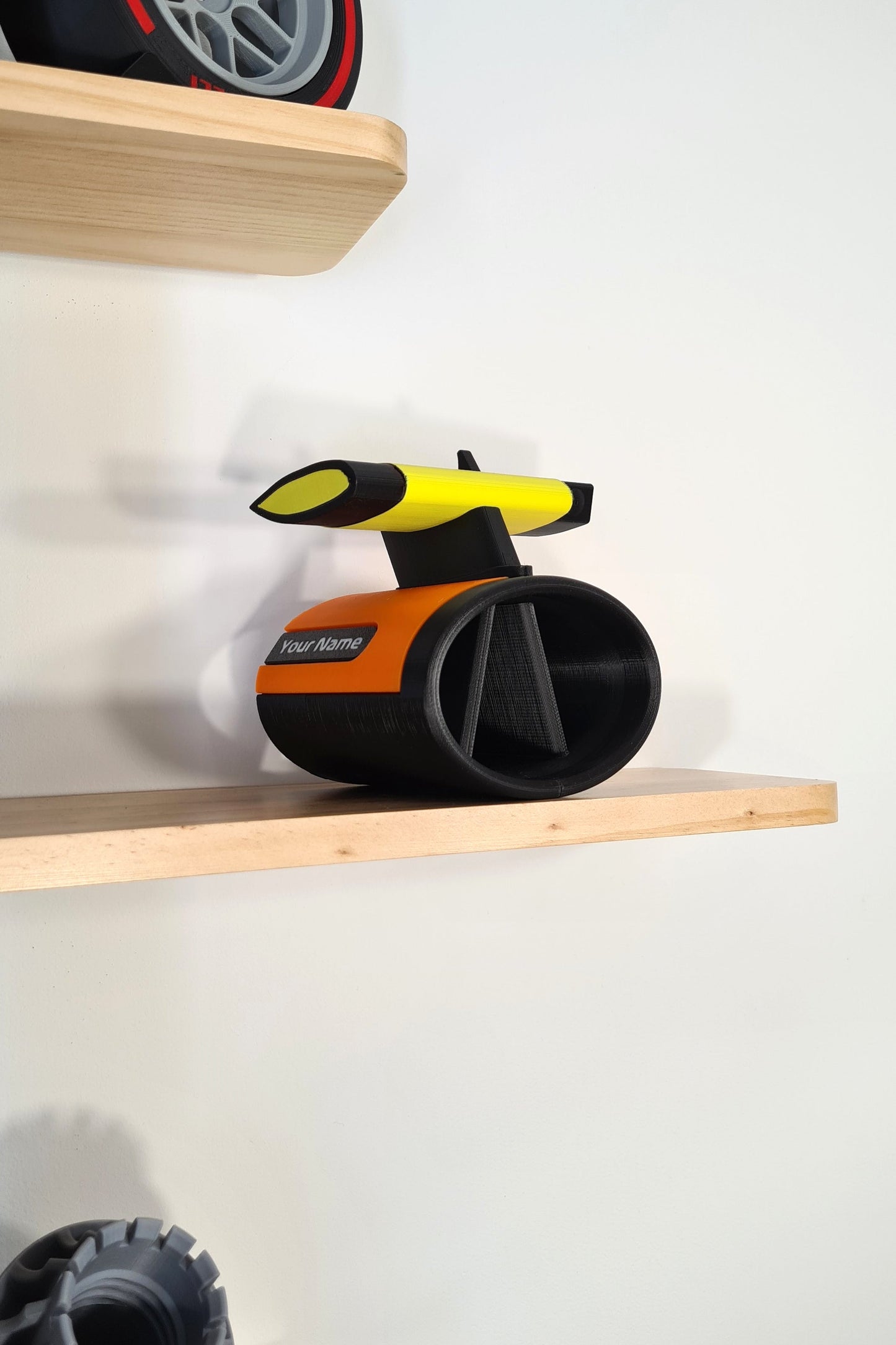 Orange and black F1 race car pen holder with yellow rear wing, personalized motorsport fan gift.
