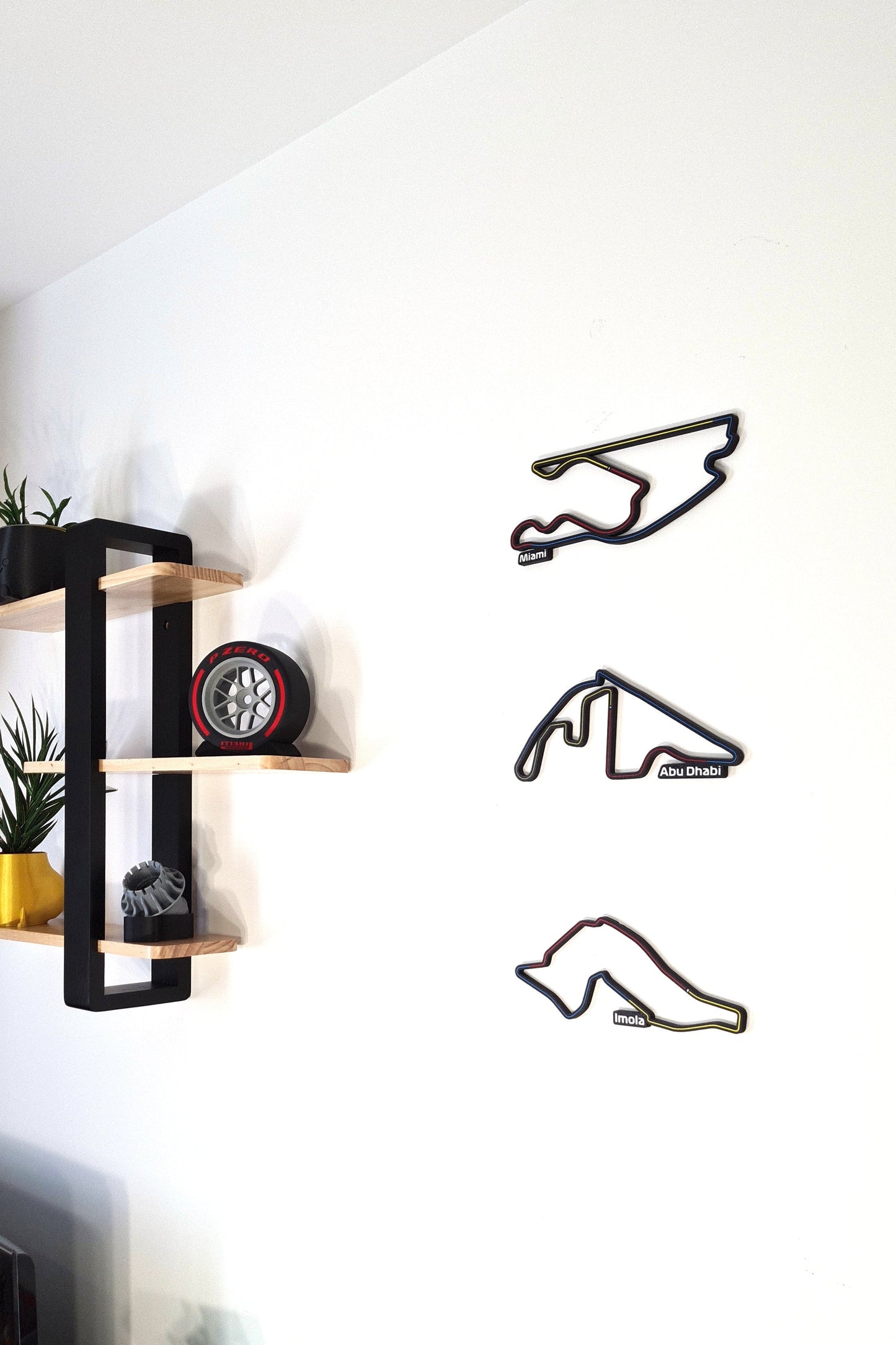 Multi-color 3D F1 circuit wall art (Miami, Abu Dhabi, Imola) and Pirelli F1 tire replica decor.