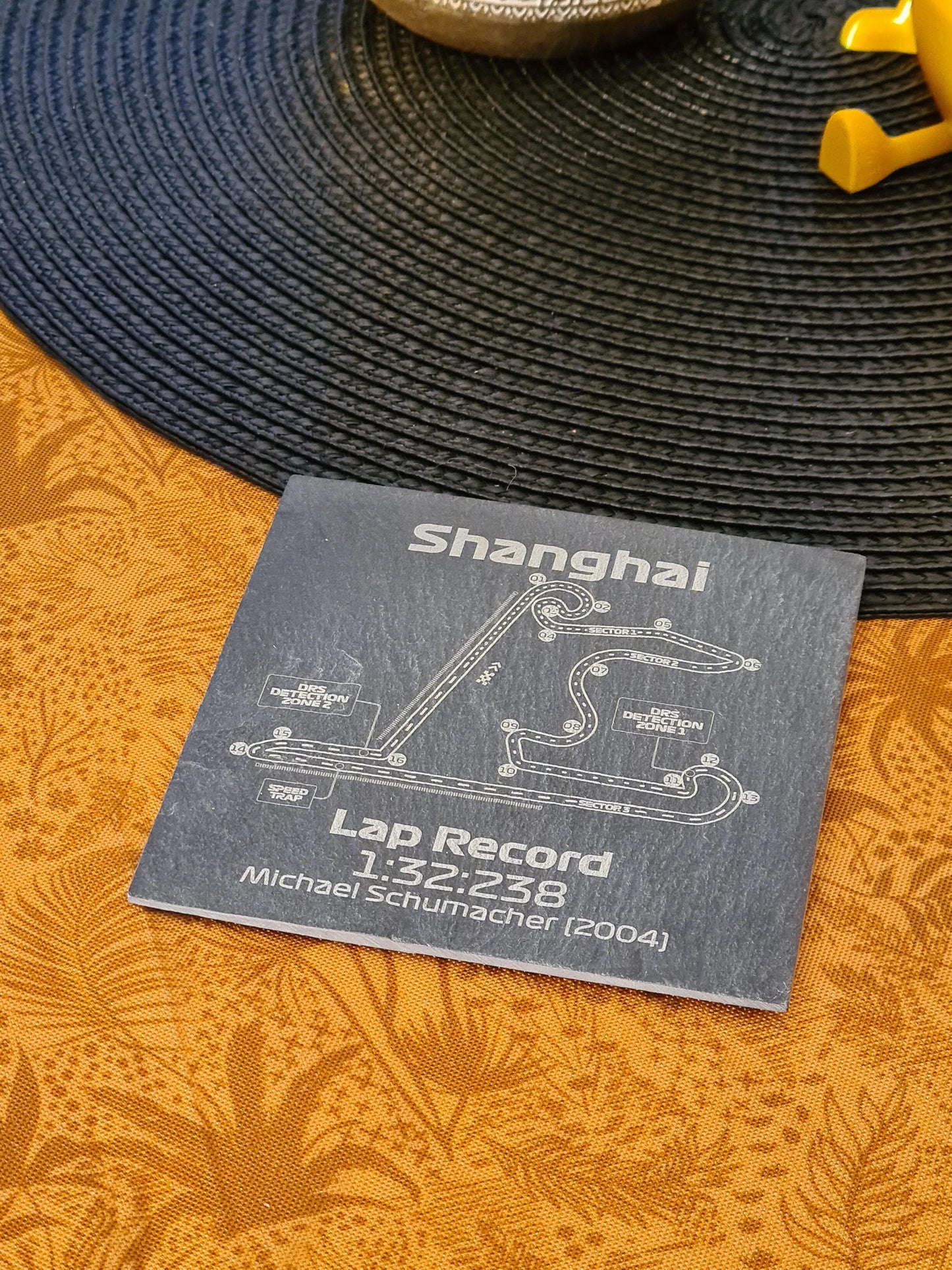 Shanghai Formula 1 circuit slate coaster with Michael Schumacher's 2004 lap record, perfect F1 fan gift.