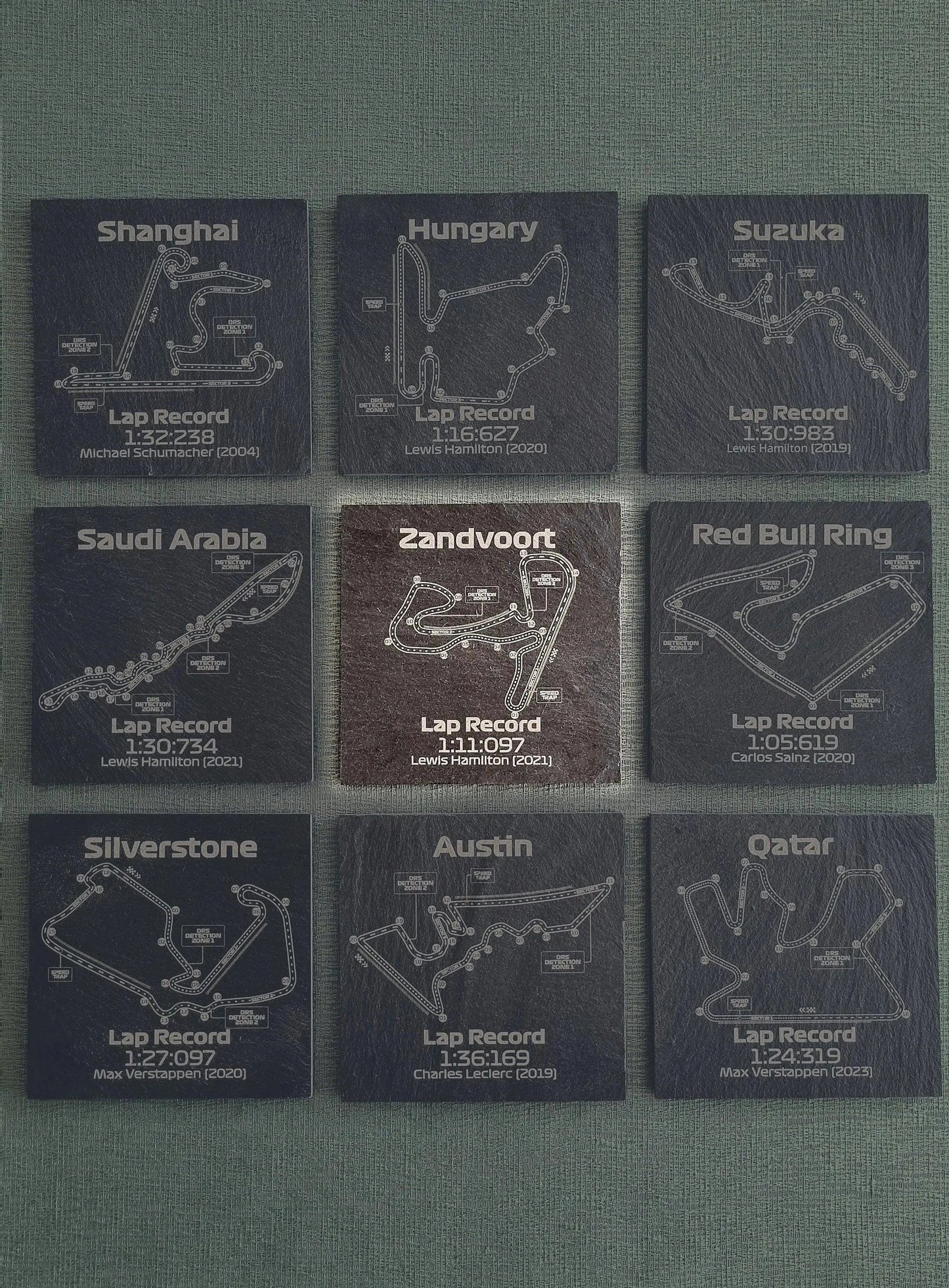 Nine slate F1 track coasters with Formula 1 circuit maps, drivers, and lap records, perfect F1 fan gift.