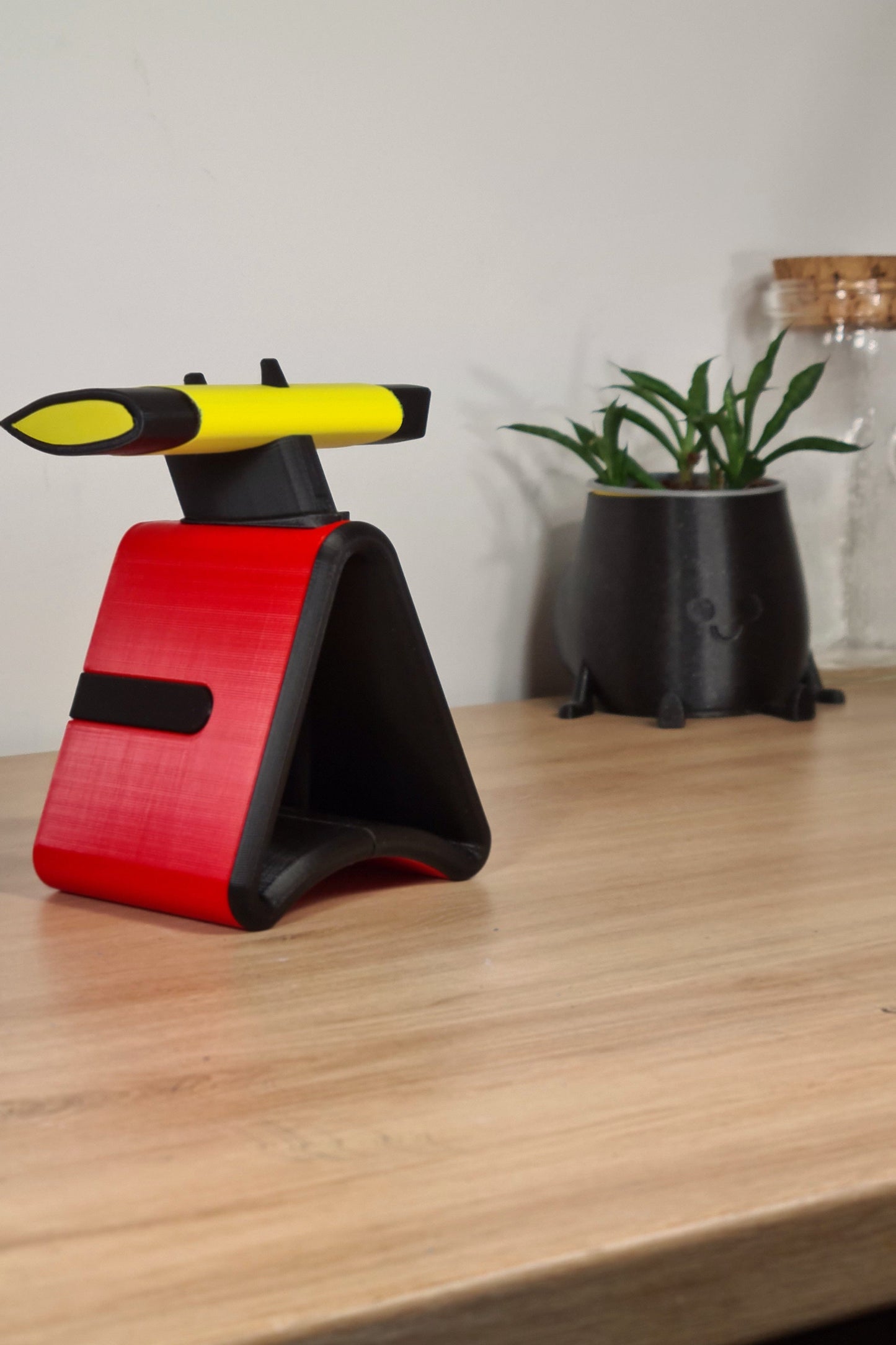 Unique F1-style phone stand, 3D printed red, black, yellow, ideal Formula 1 fan gift or office decor.