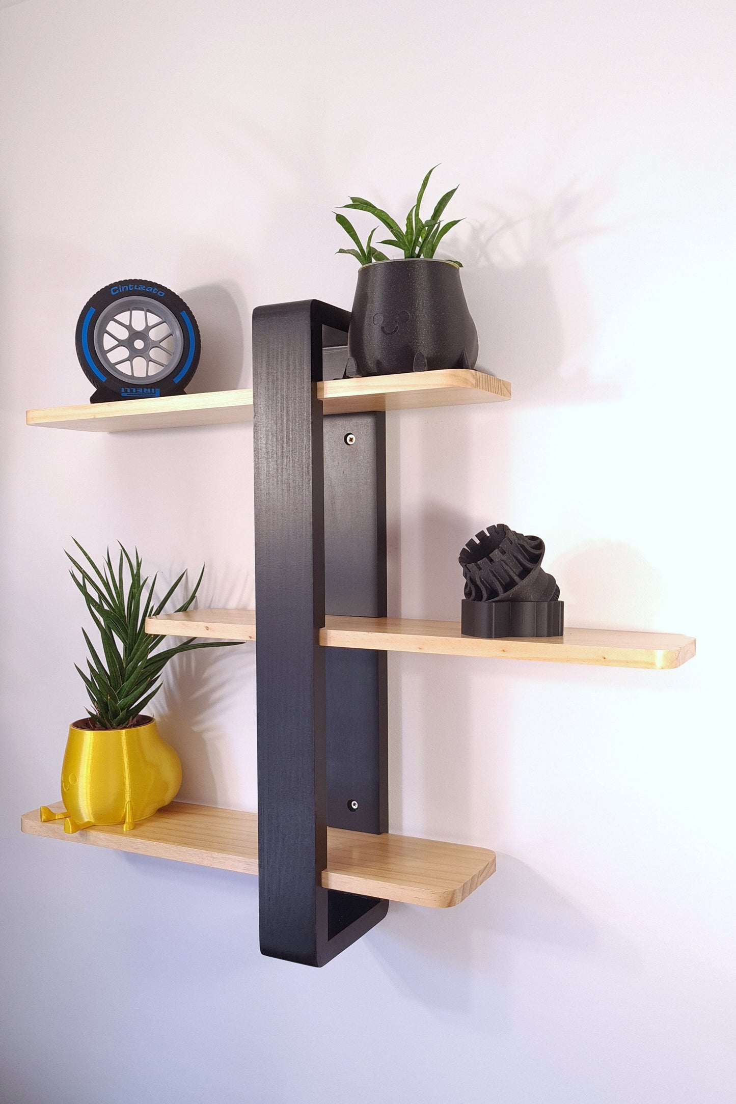3D printed Pirelli Cinturato blue F1 tire replica and motorsport decor on a modern wall display shelf.