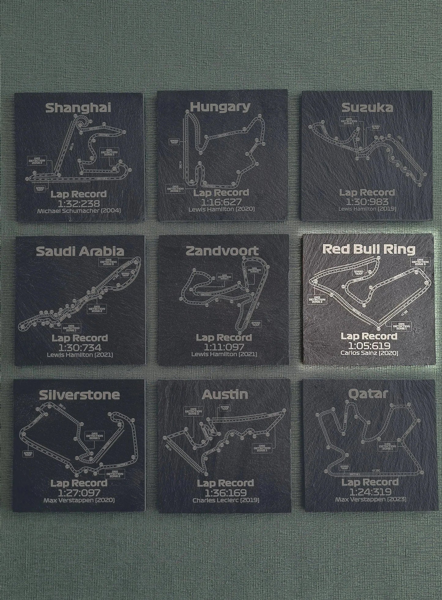 Nine F1 track slate coasters featuring legendary Formula 1 circuits and lap records, unique motorsport fan gift.