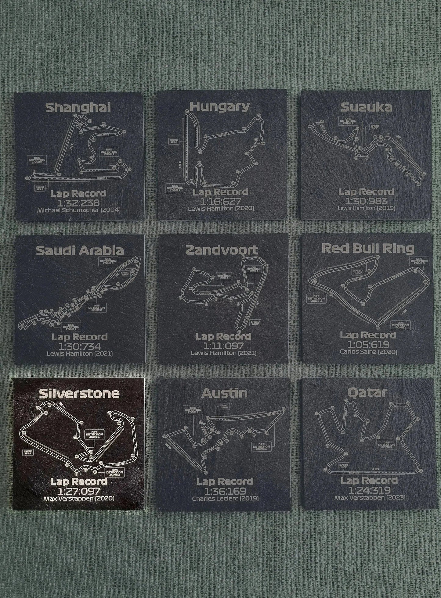 Set of 9 engraved slate F1 track map coasters featuring Grand Prix circuits and lap records, perfect gift for motorsport fans.