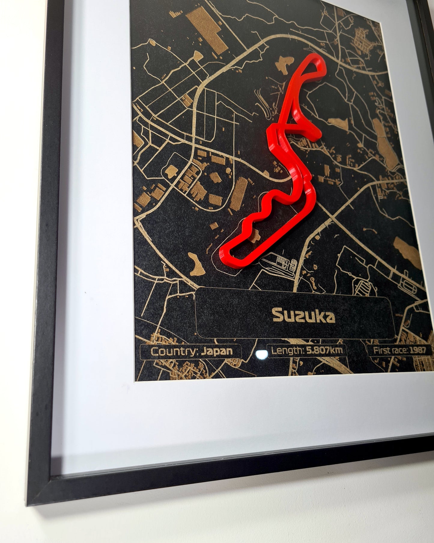 Framed Suzuka Formula 1 track 3D wall art with red circuit on black and gold map, perfect F1 fan gift.