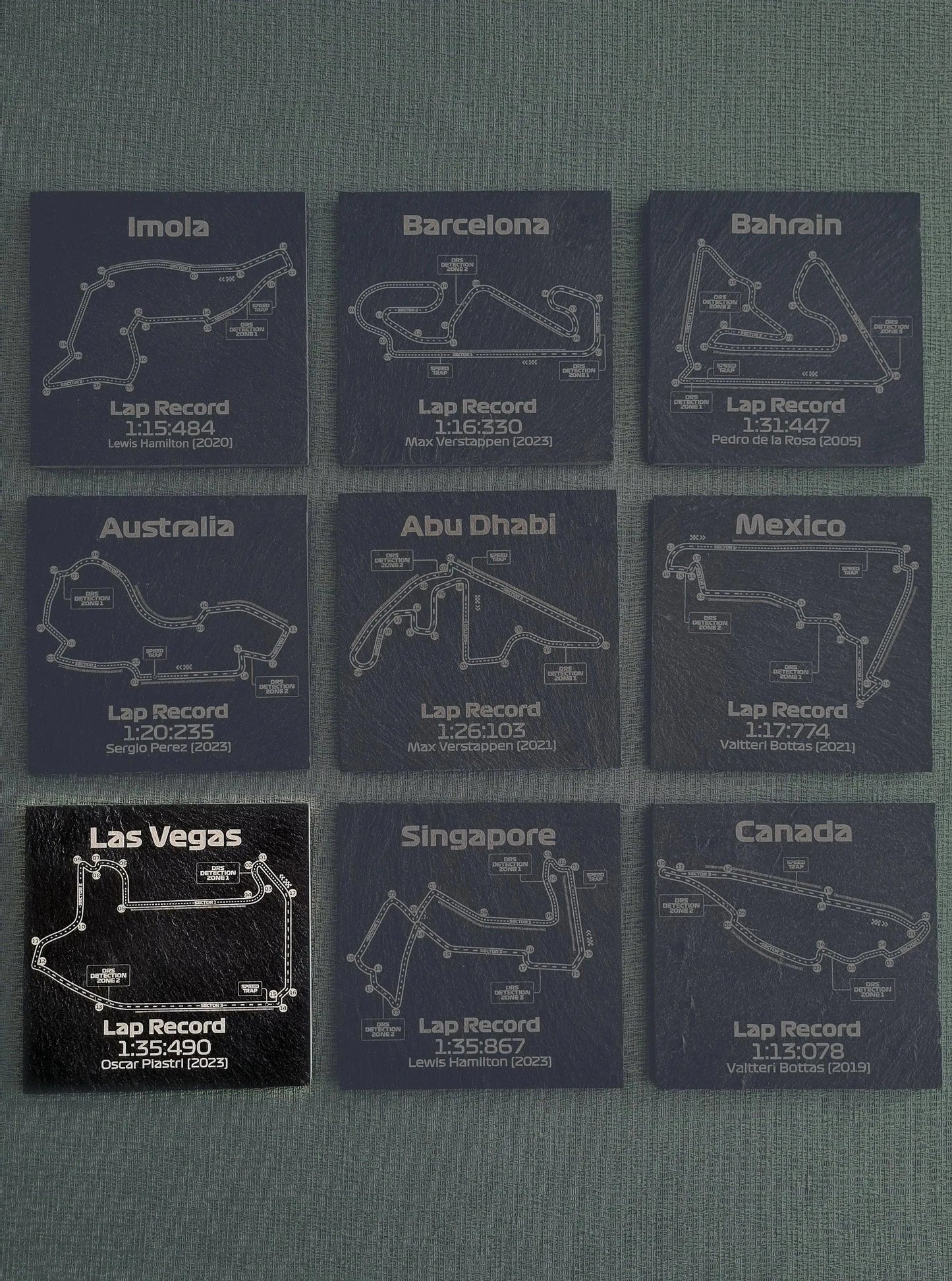 Set of 9 F1 track map slate coasters with lap records for various Grand Prix circuits, ideal F1 fan gift.