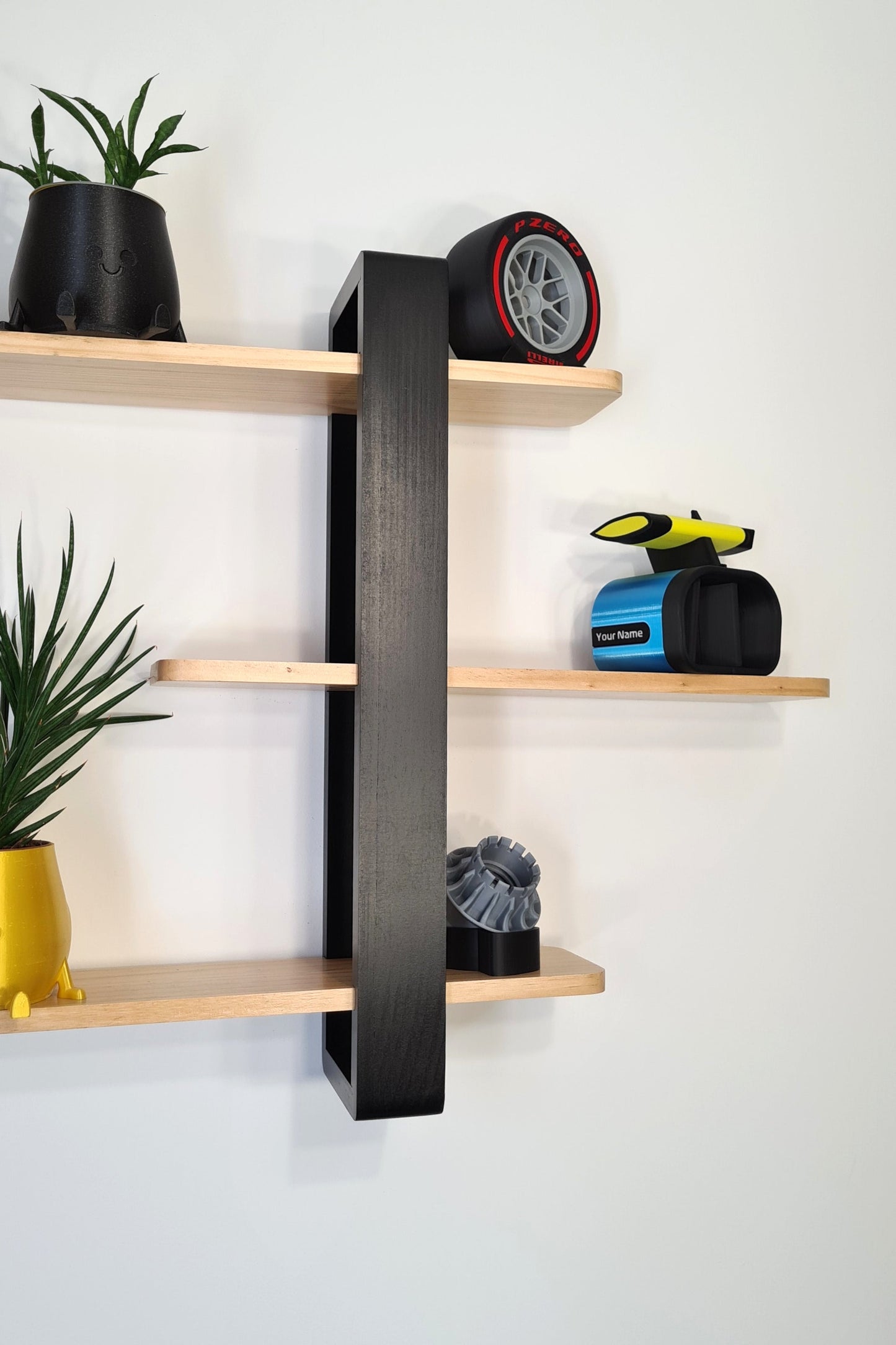 F1 decor display featuring Pirelli red tire replica, personalized blue F1 phone stand, and wheel nut model.
