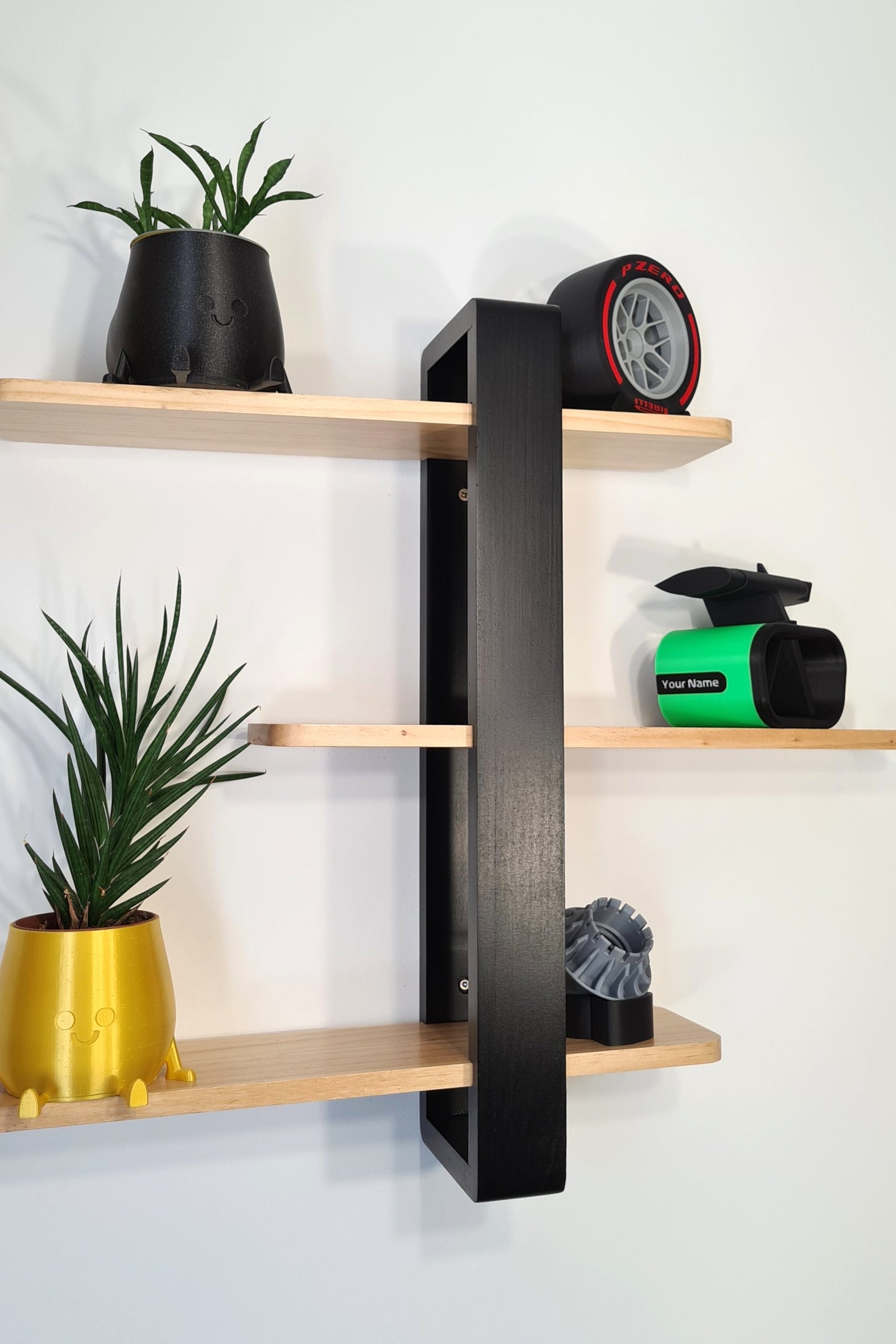 F1 Pirelli P Zero tire replica, custom green F1 car nose cone, and turbine wheel hub model on display shelves.