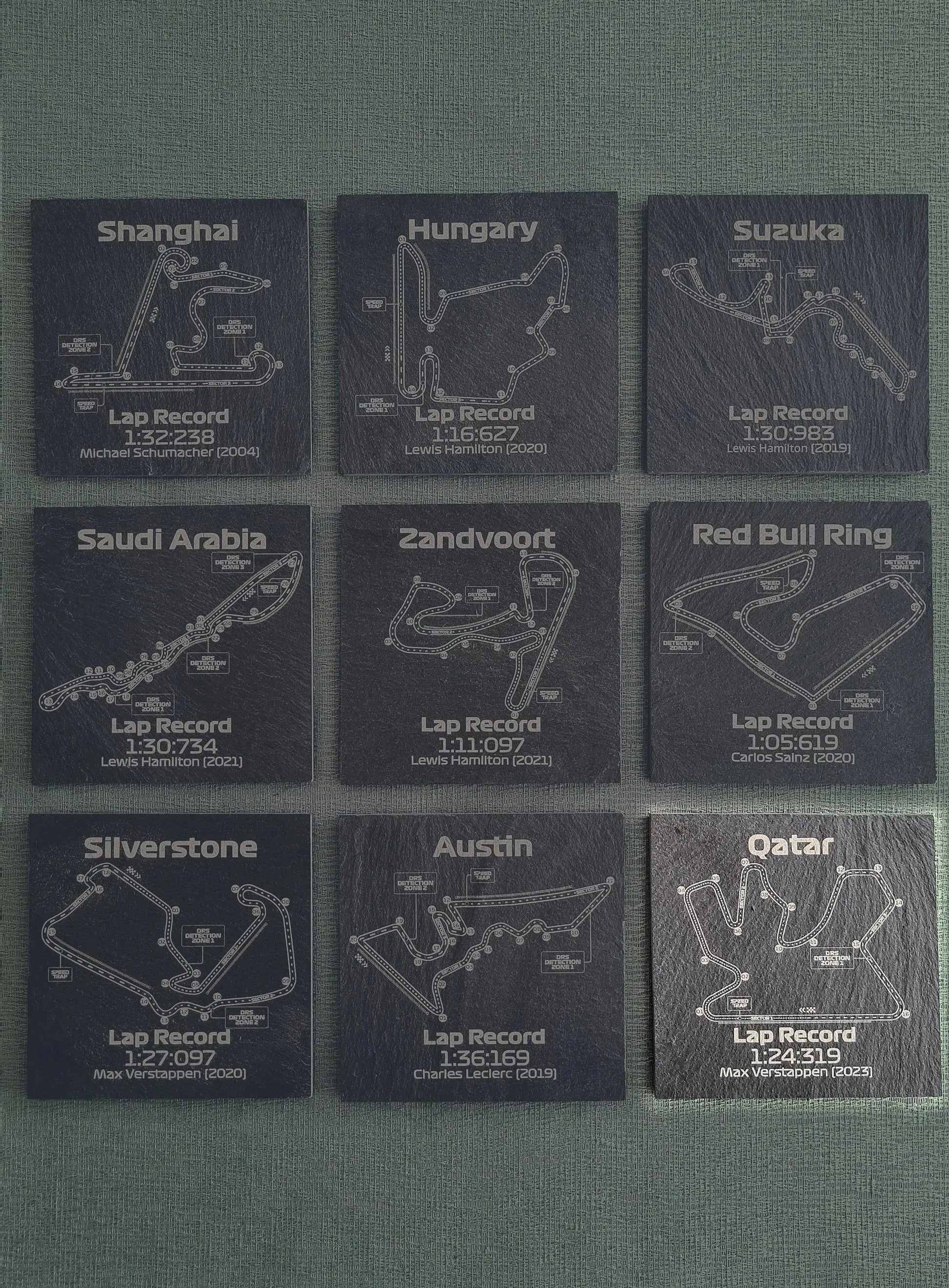Set of 9 F1 circuit slate coasters featuring various track maps and lap records, perfect Formula 1 fan gift.