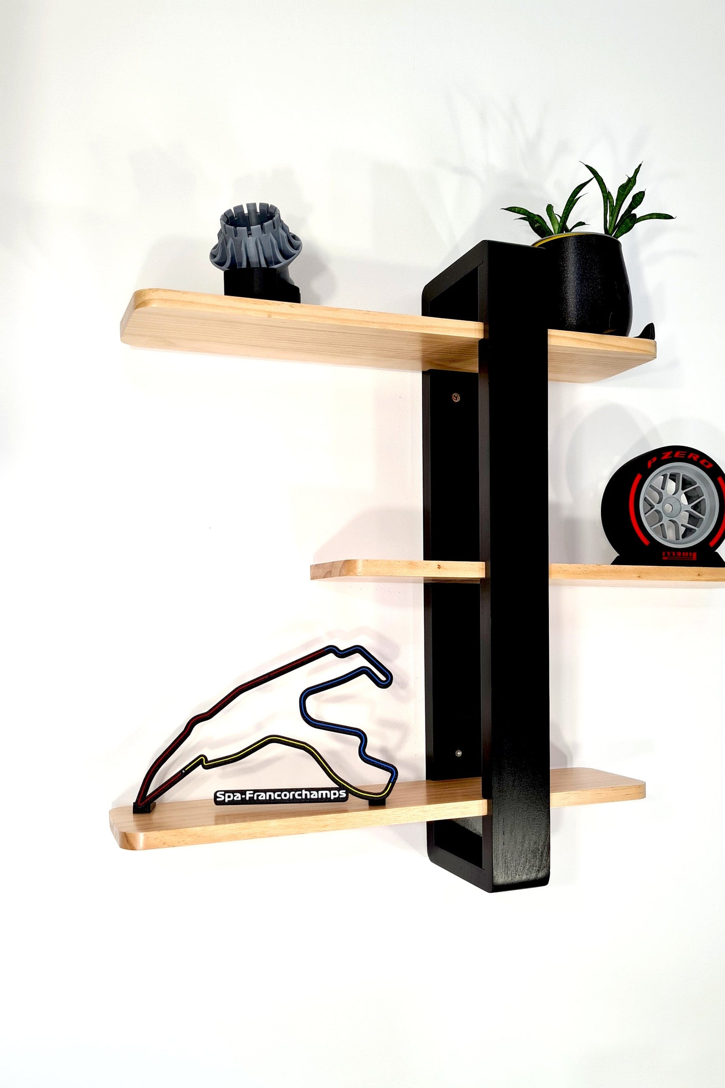 Stylish black and wood wall shelf with Spa-Francorchamps F1 track, Pirelli tire replica, perfect F1 fan gift.