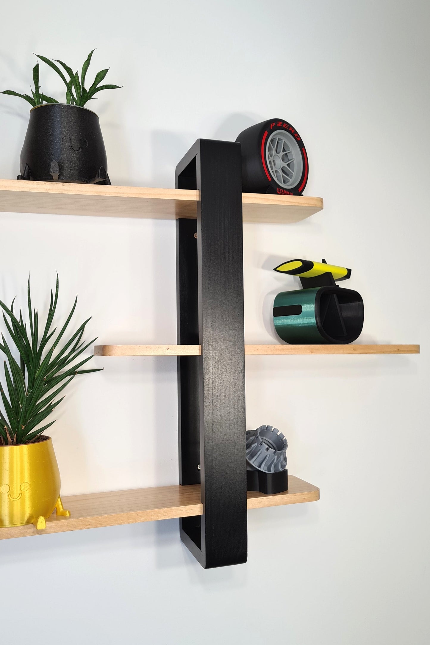 F1 decor display featuring a Pirelli Formula 1 tire replica, green F1 car model, and wheel nut on a black wall shelf.