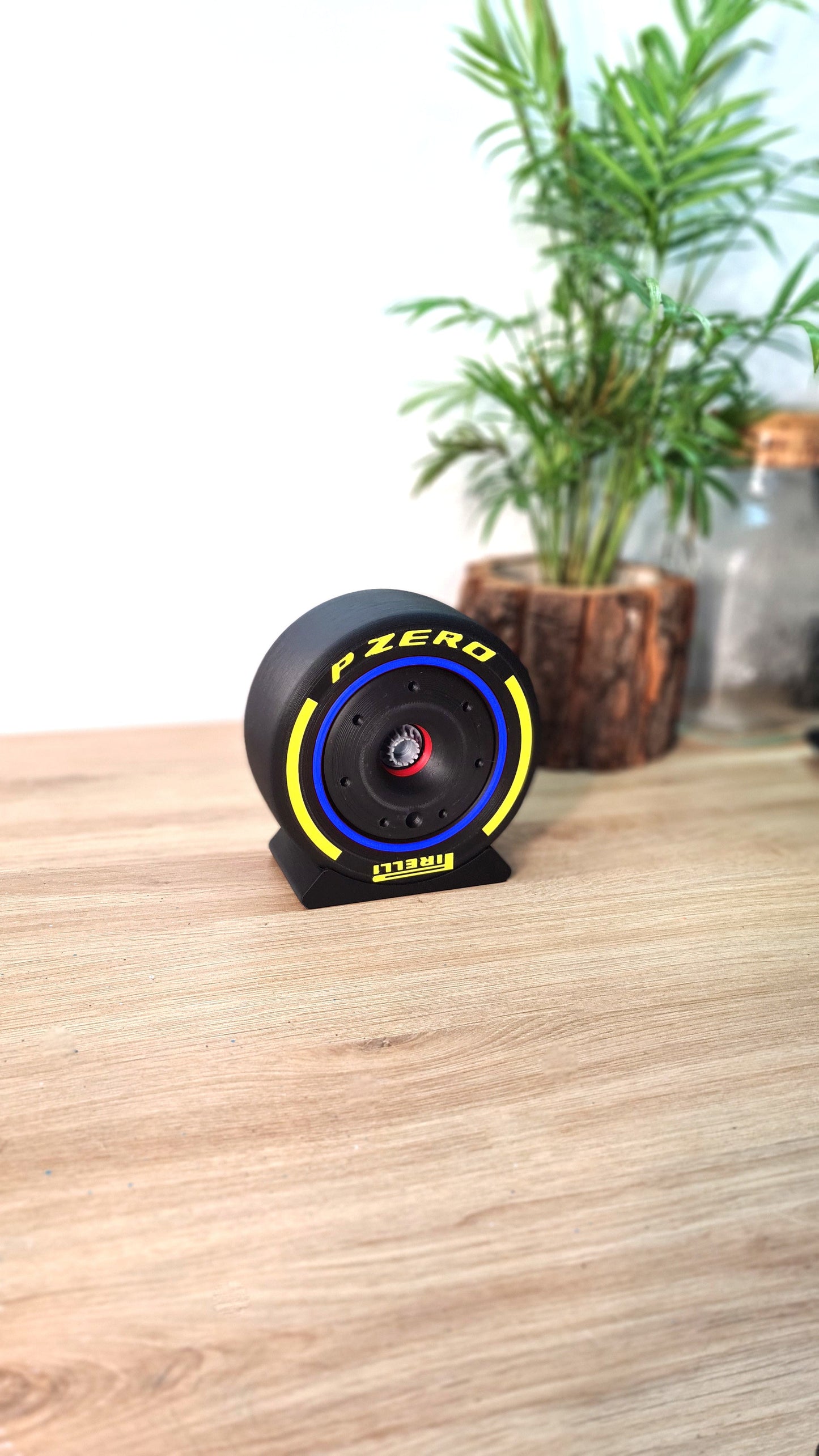 Pirelli P Zero F1 tire replica with yellow and blue stripes on display stand, great F1 fan gift.