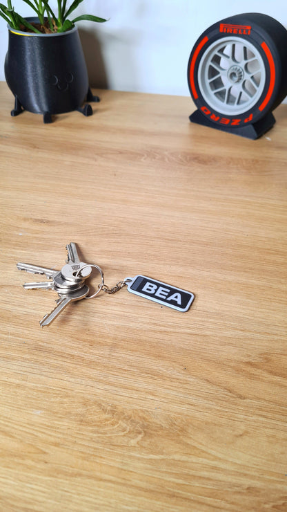 Personalized 'BEA' F1 keychain in black and white, perfect gift for motorsport fans.