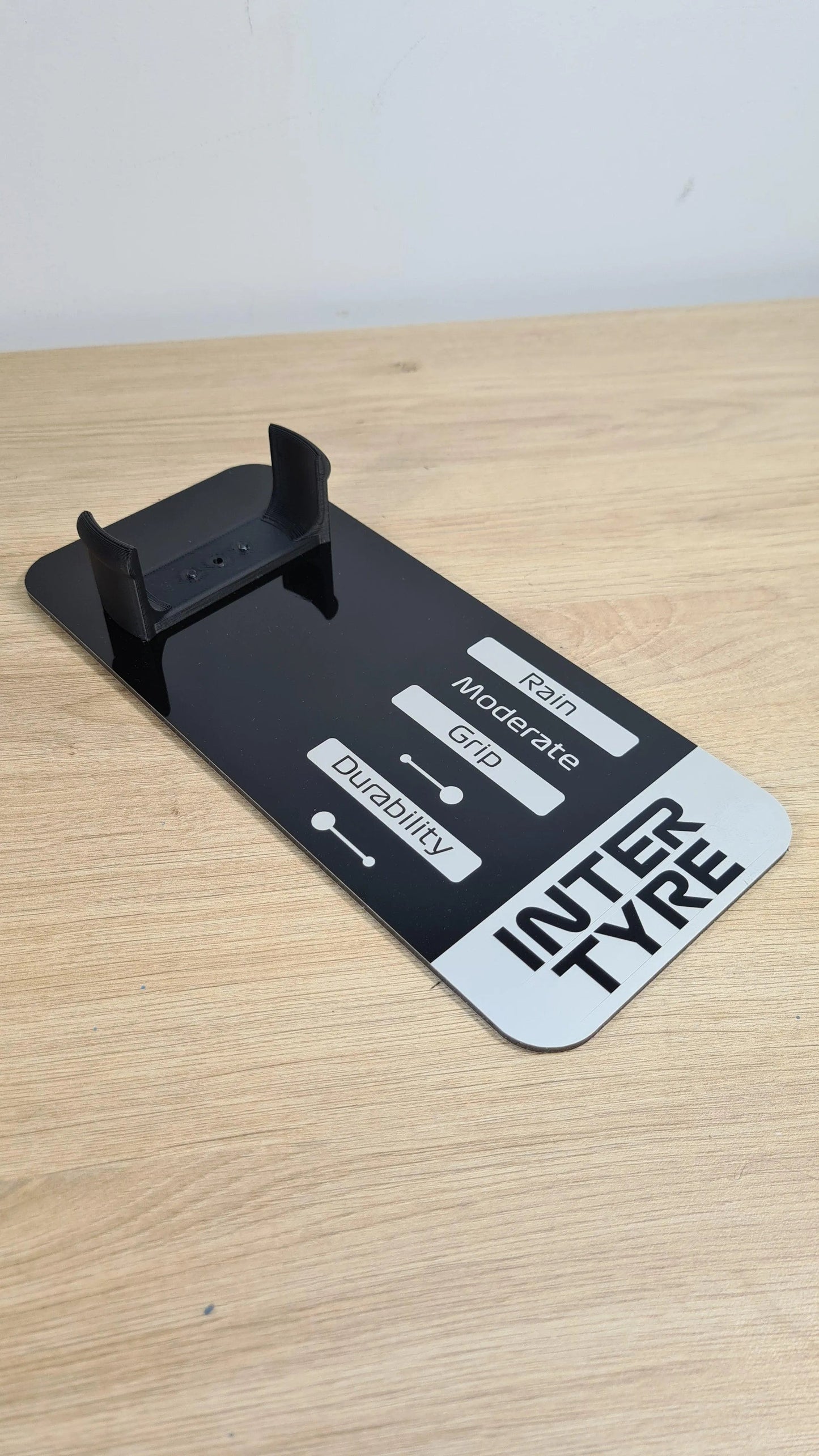 Black F1 INTER TYRE model wheel display stand with rain, grip, durability indicators for F1 fans.