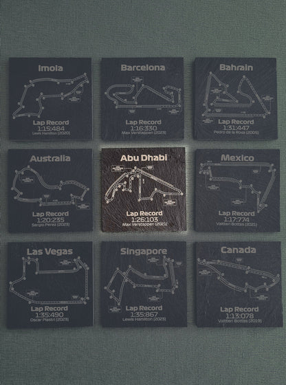 Set of nine dark glass coasters, each featuring different Formula 1 track outlines such as Abu Dhabi, Barcelona, and Mexico, with recorded fastest lap times and drivers' names like Max Verstappen and Lewis Hamilton.