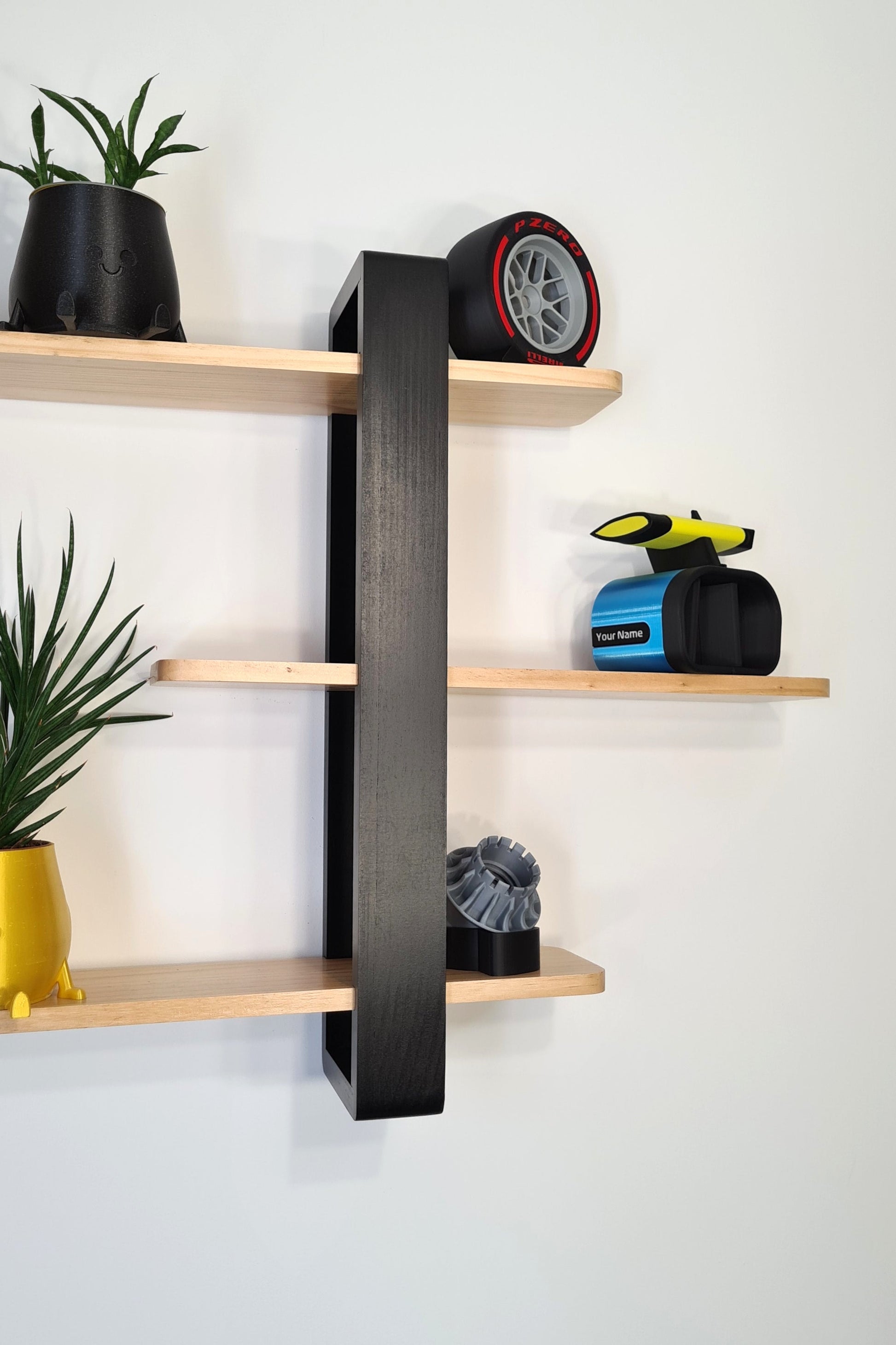 F1 decor display featuring Pirelli red tire replica, personalized blue F1 phone stand, and wheel nut model.